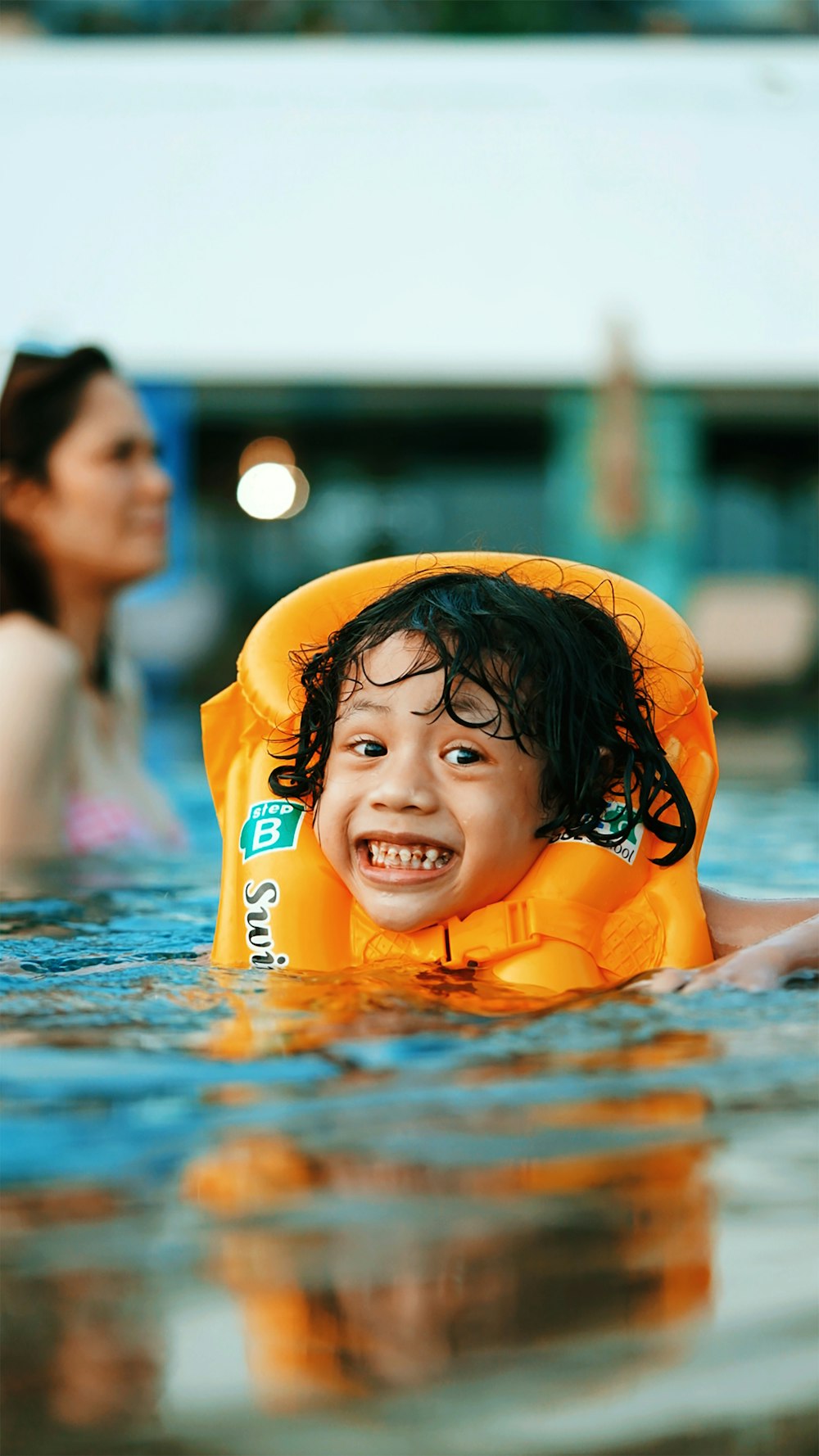 girl in white tank top on swimming pool during daytime