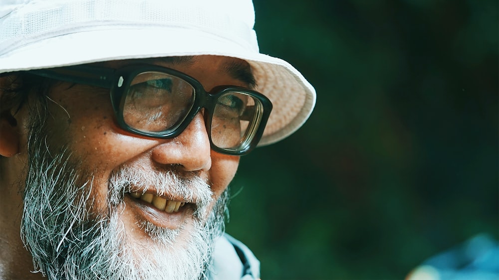 man in black framed eyeglasses and white cap