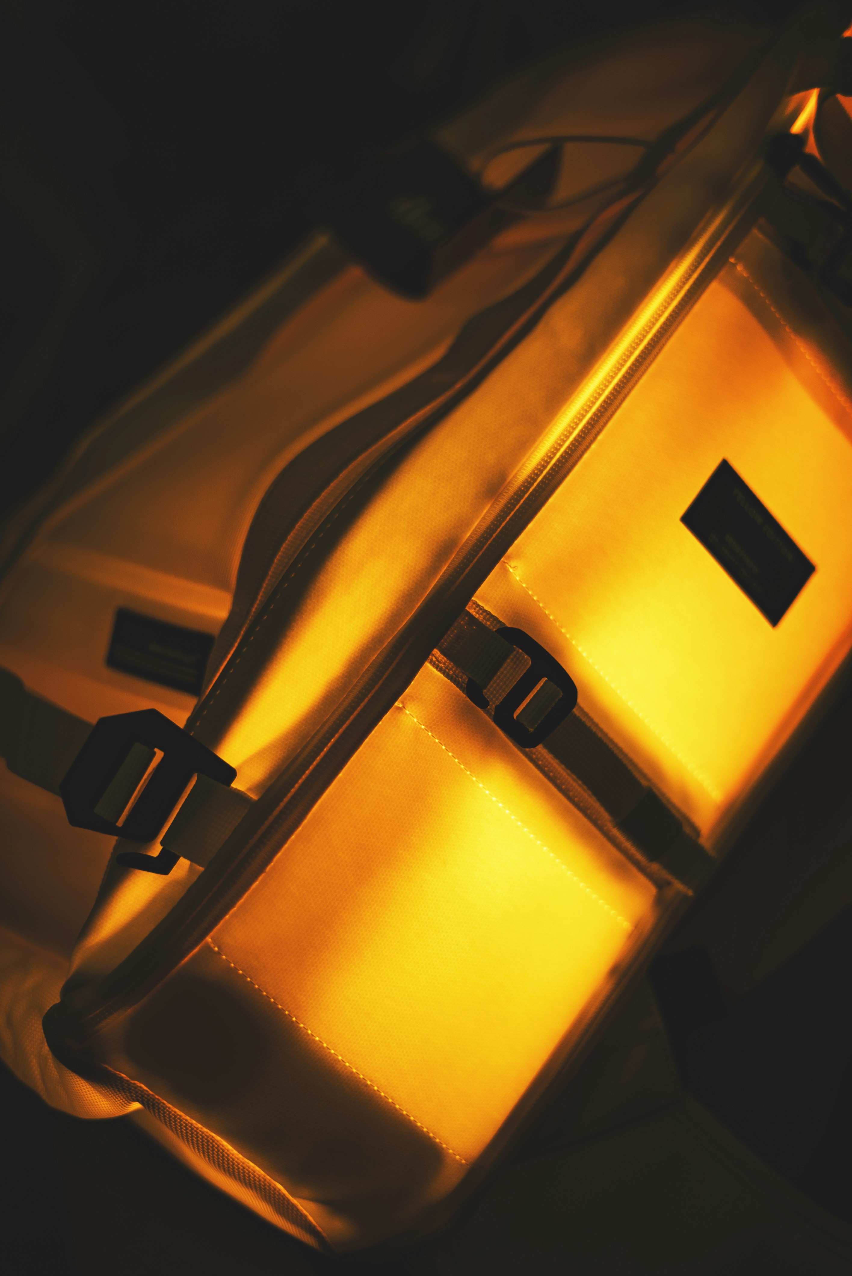 Colorful backpack glowing with mysterious light in a dark room