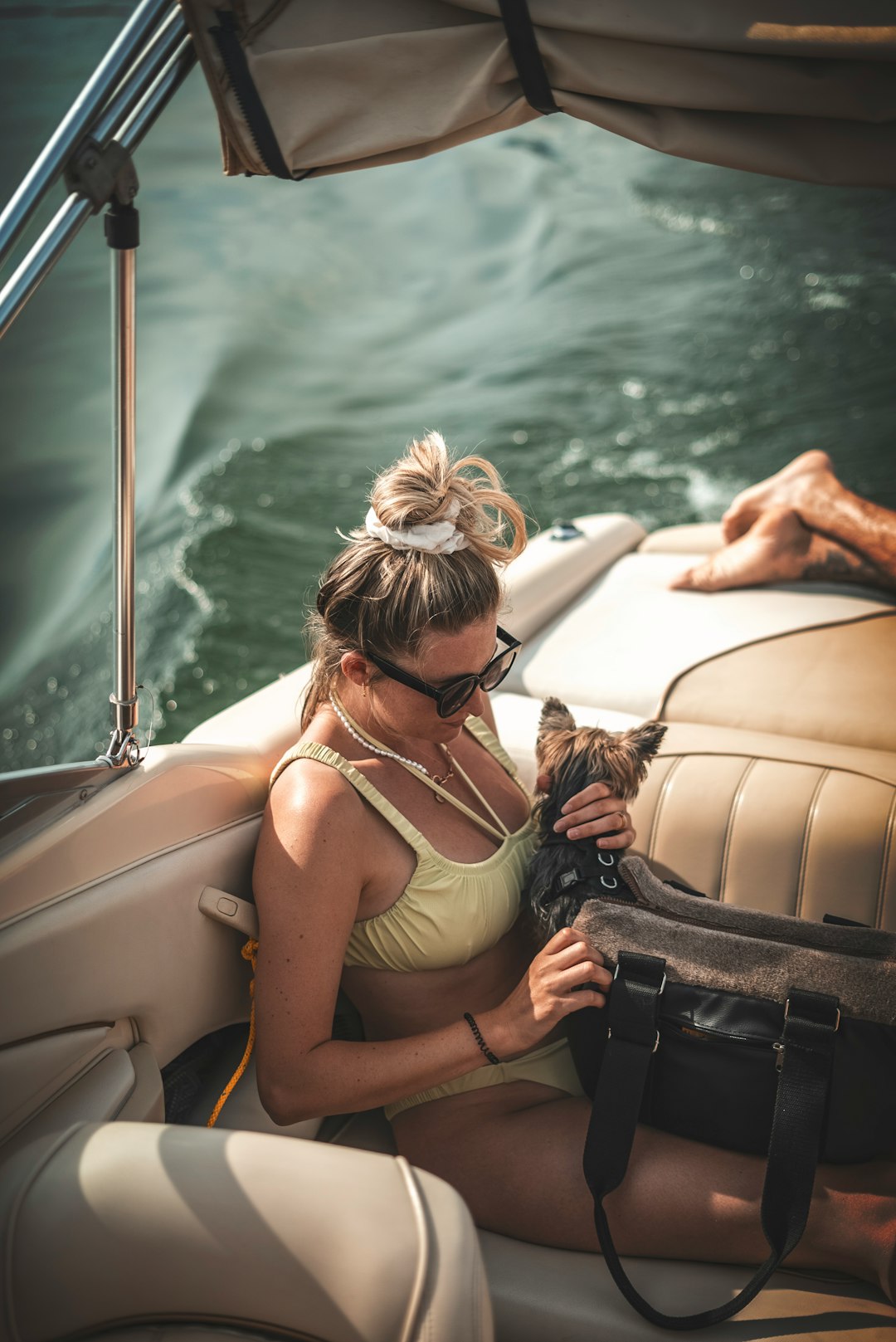 woman in gray tank top sitting on white and black boat during daytime