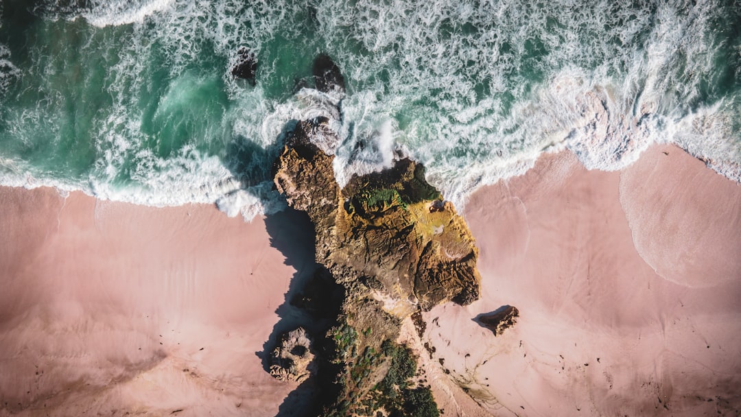 brown rock formation beside body of water during daytime