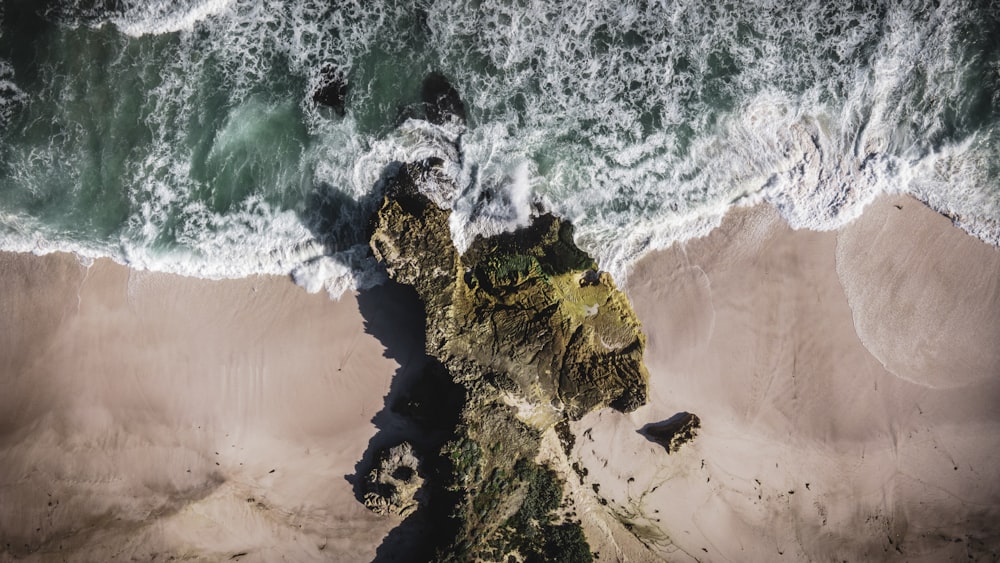 brown rock formation beside body of water during daytime