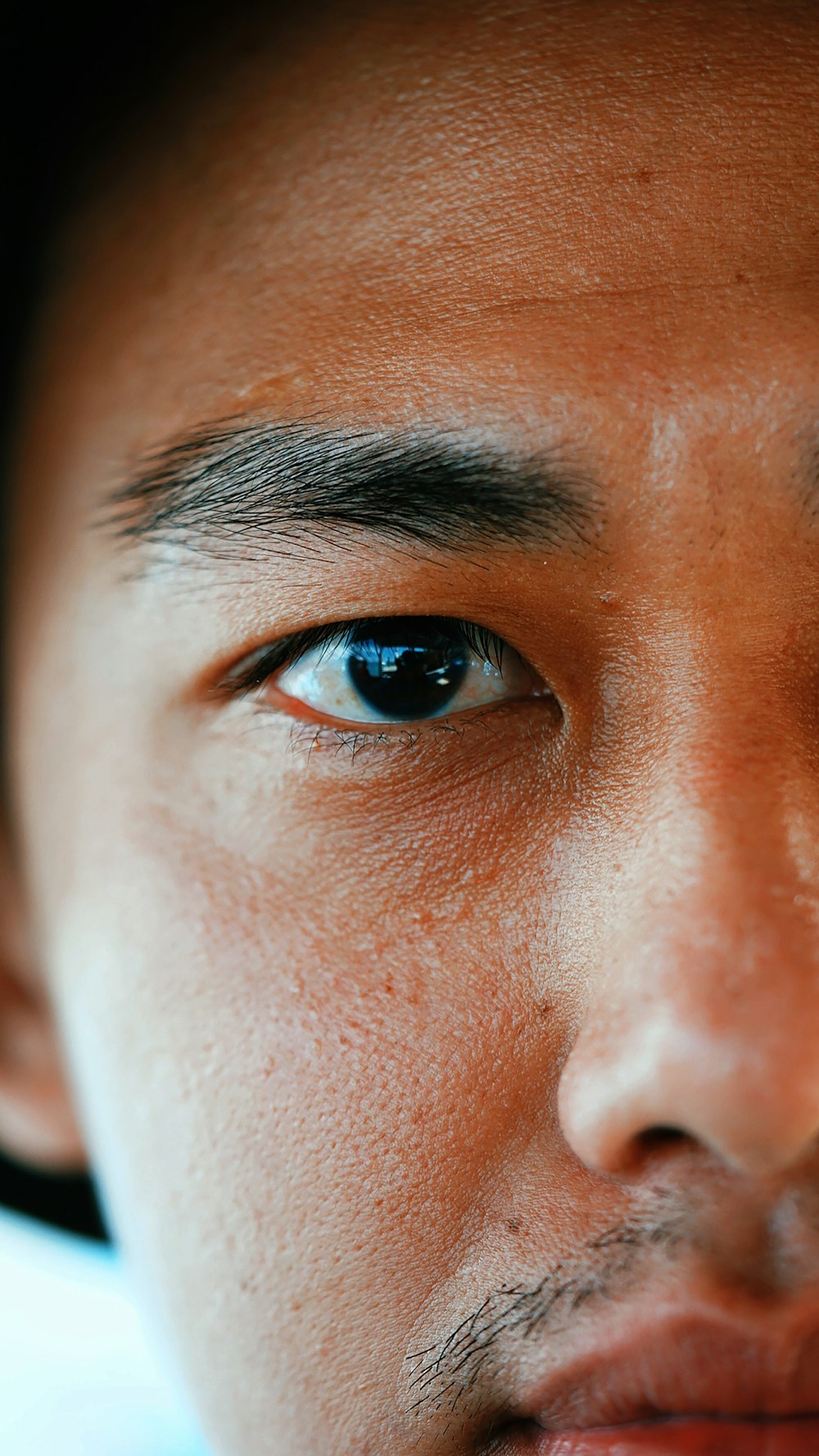 persons blue eyes in close up photography