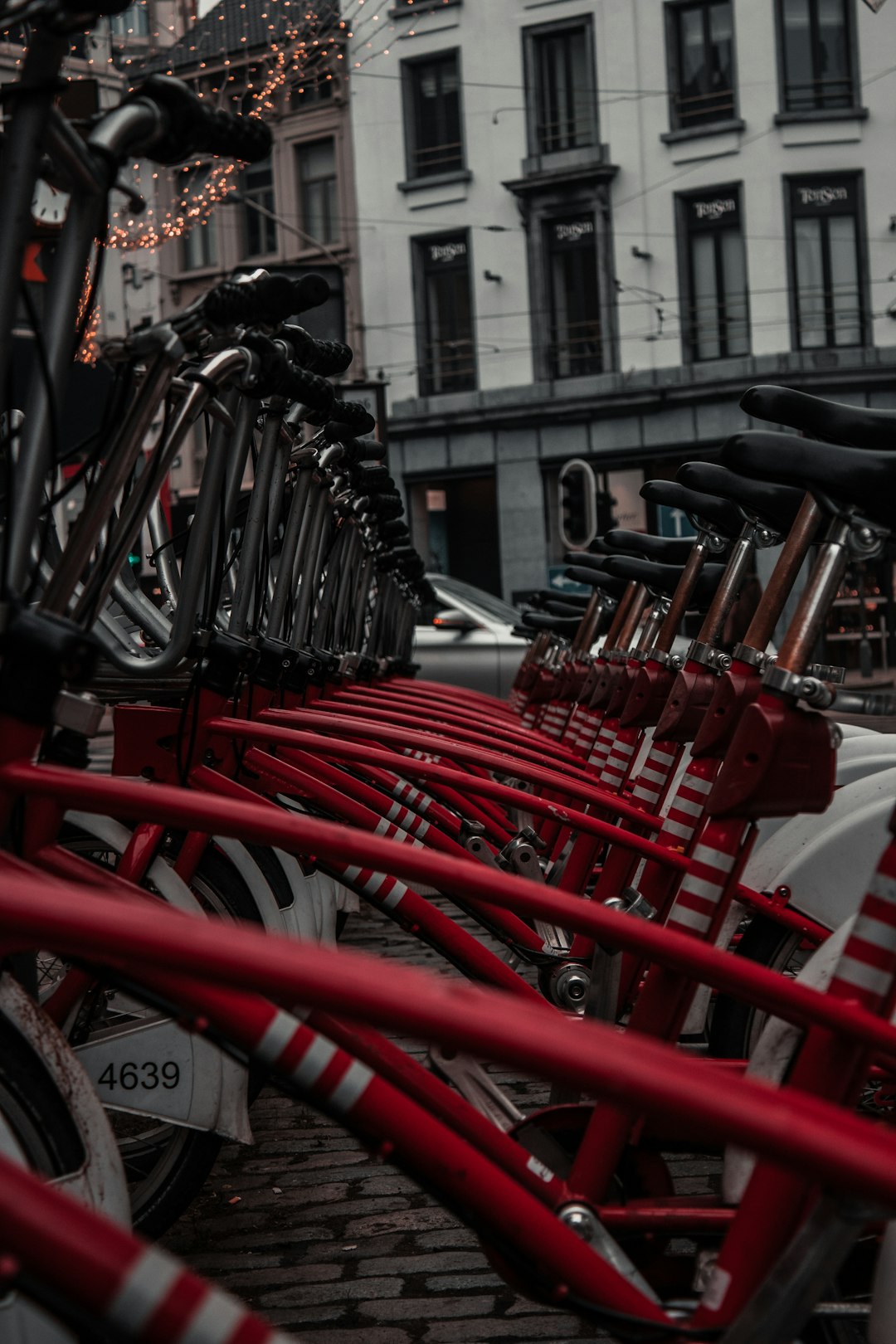 red and black bicycle parked on sidewalk during daytime