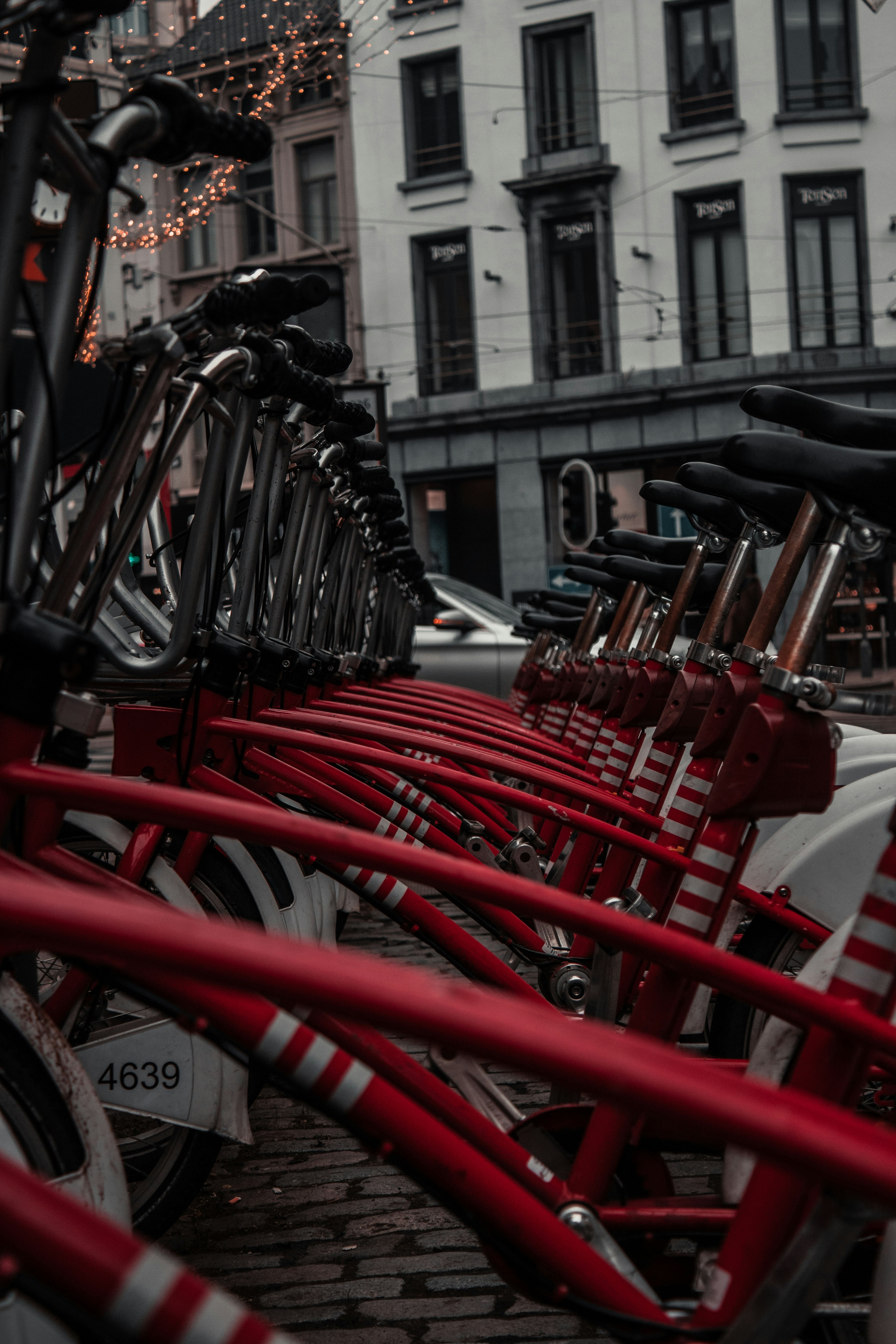 red and black bicycle parked on sidewalk during daytime