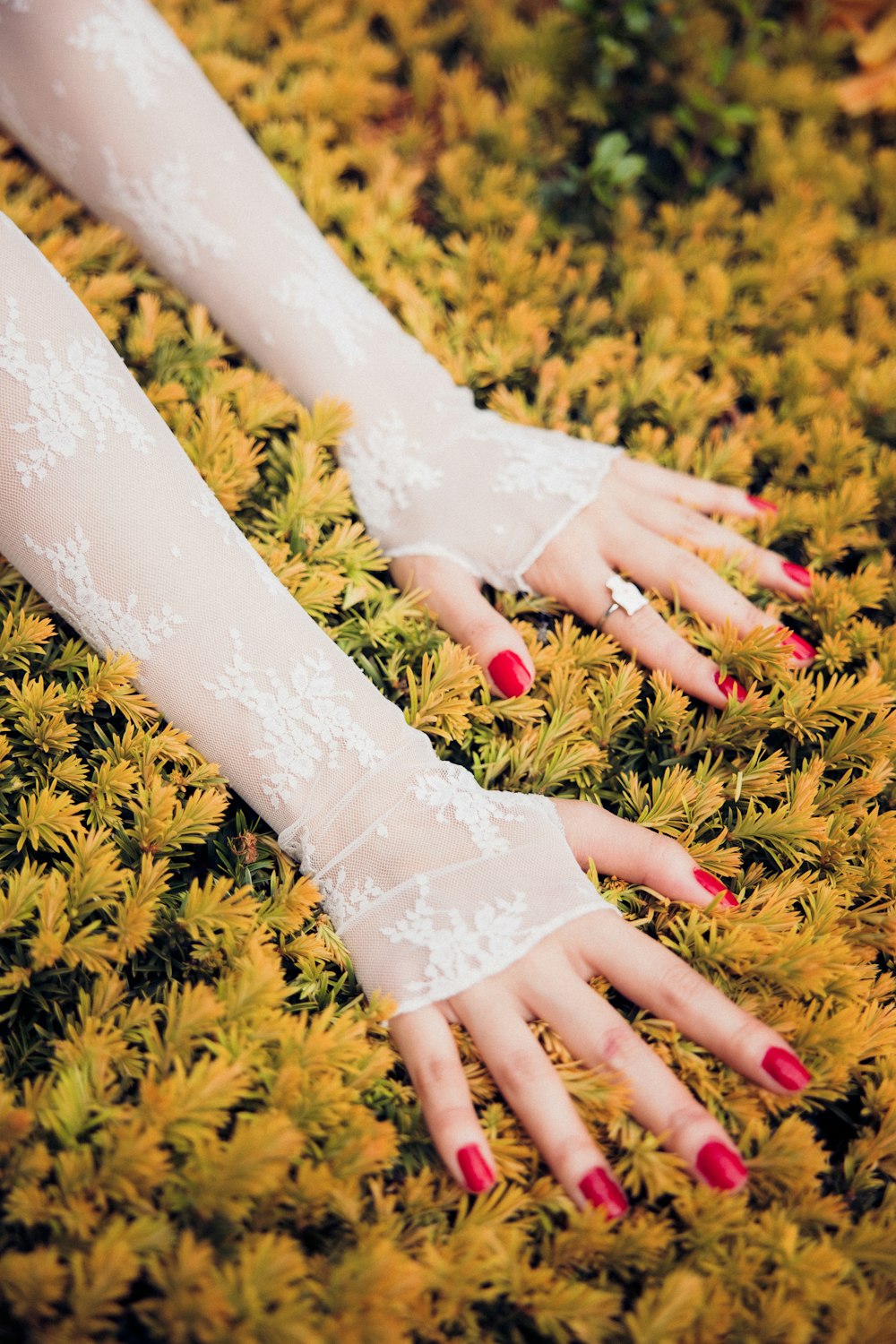woman in white lace dress with red manicure