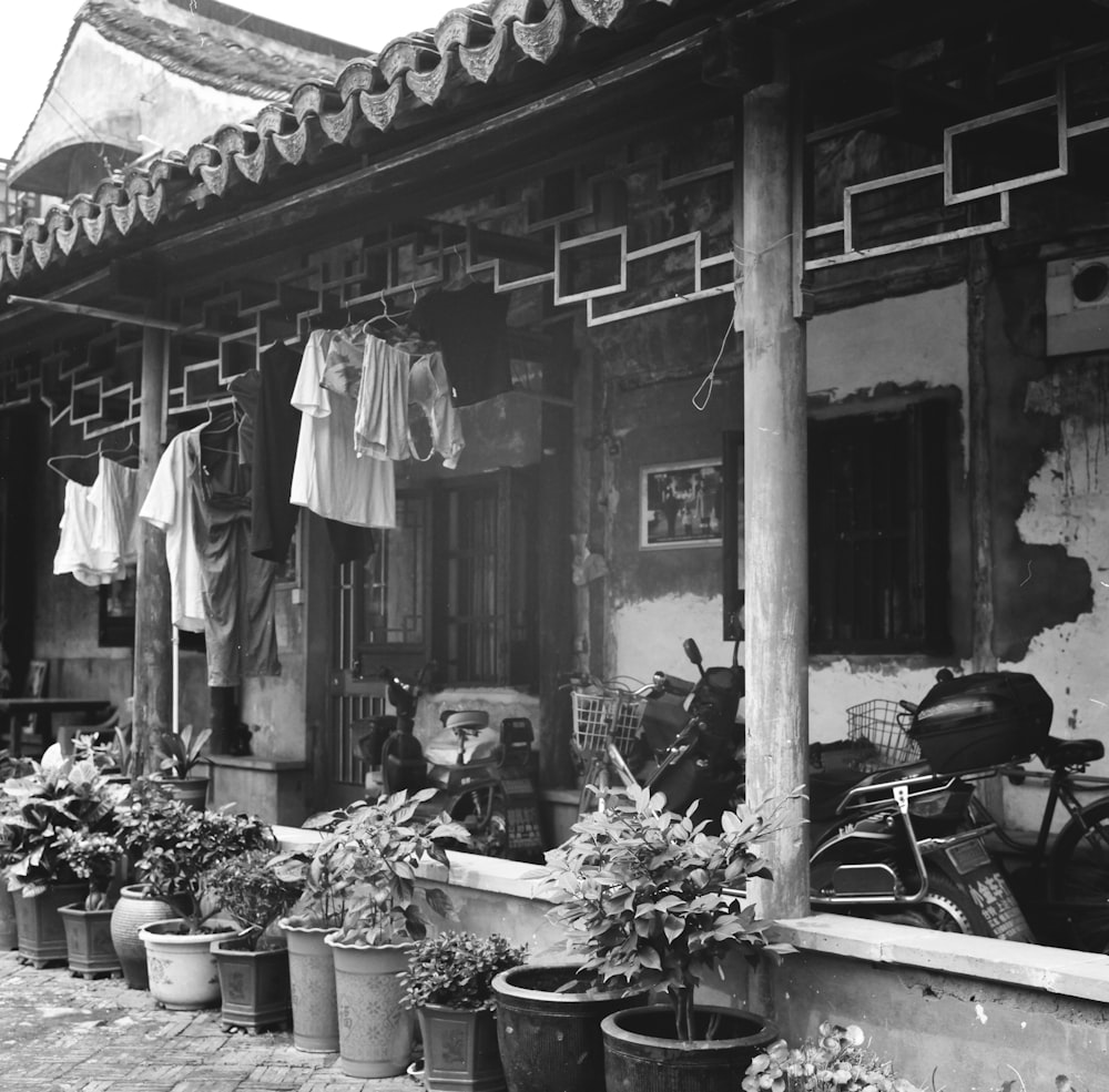 grayscale photo of man in black jacket standing near store