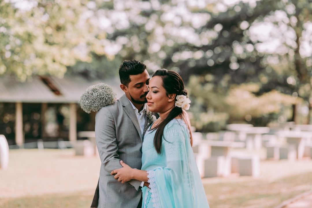 man in gray suit jacket kissing woman in blue dress