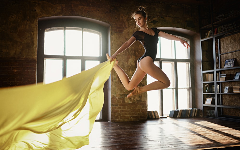 woman in black tank top and yellow skirt holding yellow textile