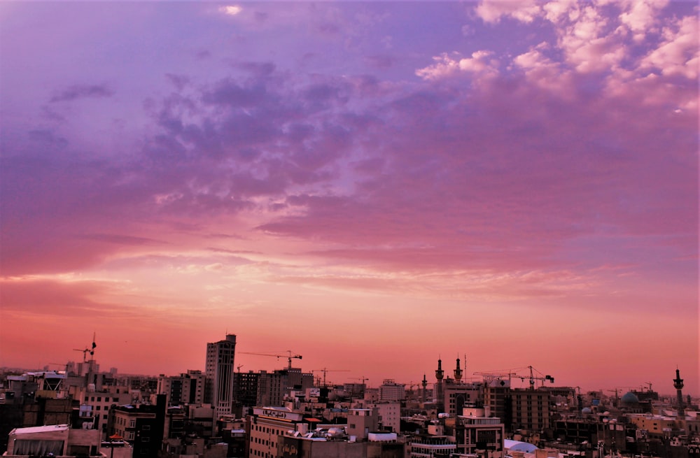 city skyline under orange and blue sky during sunset