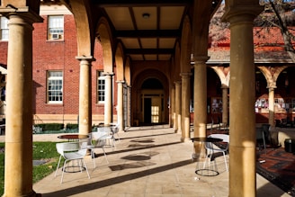 black metal chairs and table near brown concrete building during daytime