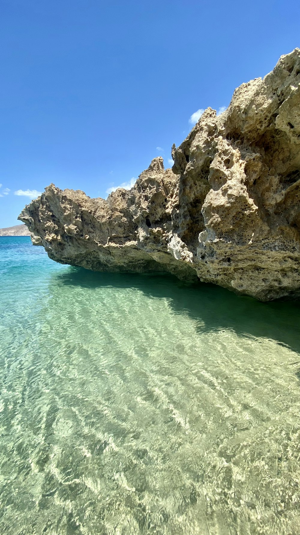 brown rock formation on blue sea under blue sky during daytime