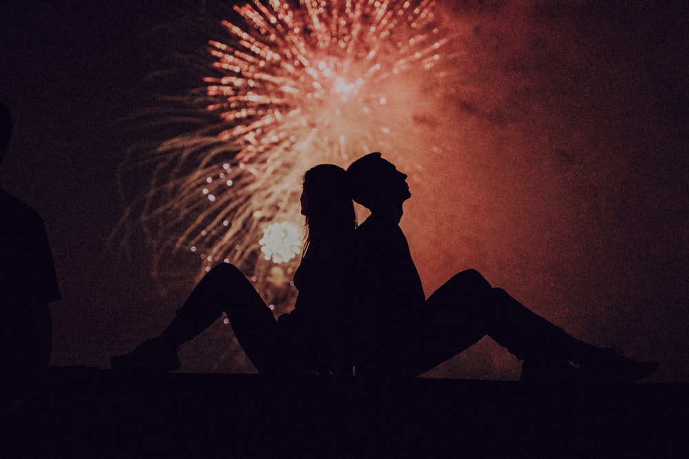 silhouette of man and woman kissing under fireworks