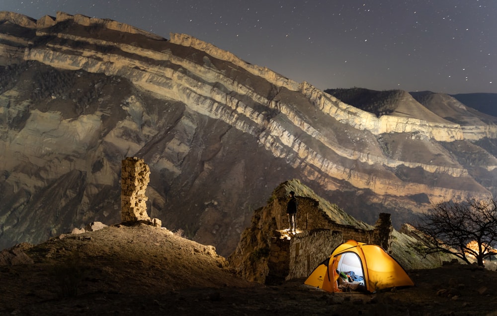 yellow dome tent on brown rock mountain during daytime