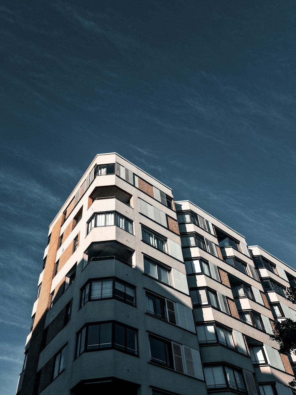 Weißes Betongebäude unter blauem Himmel tagsüber