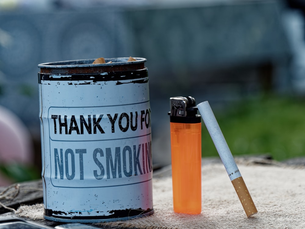 orange and white cigarette stick on blue and white can