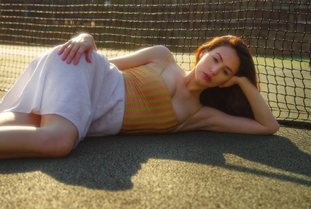 woman in white tank top lying on brown carpet