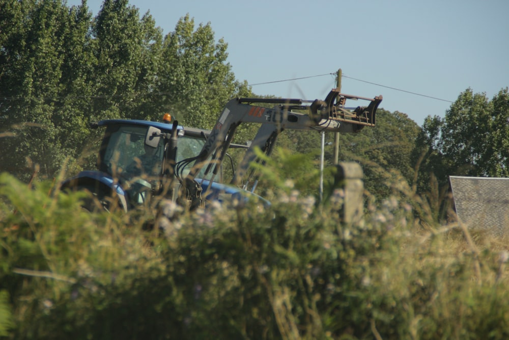 blue and black heavy equipment on green grass field during daytime