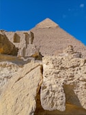 A close-up of the Great Pyramid's weathered limestone blocks glowing under a golden sunset.