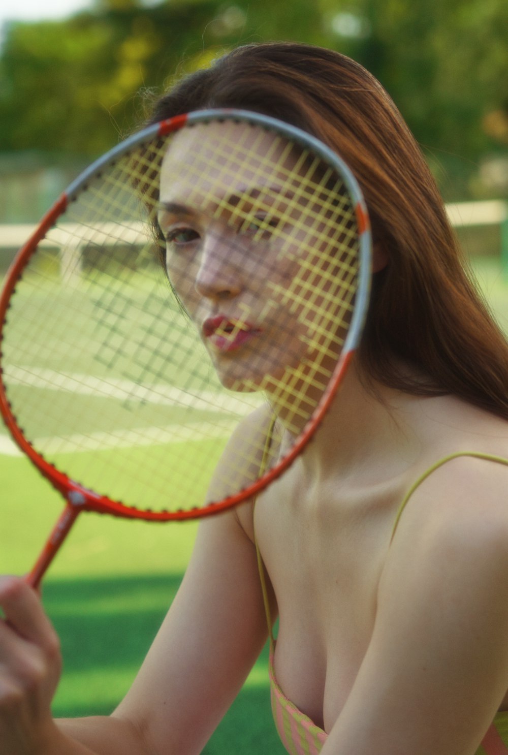 woman holding red and white tennis racket