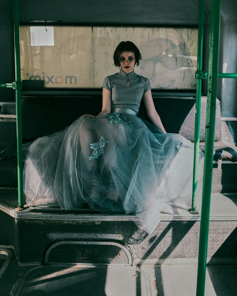 woman in white wedding gown sitting on black suitcase