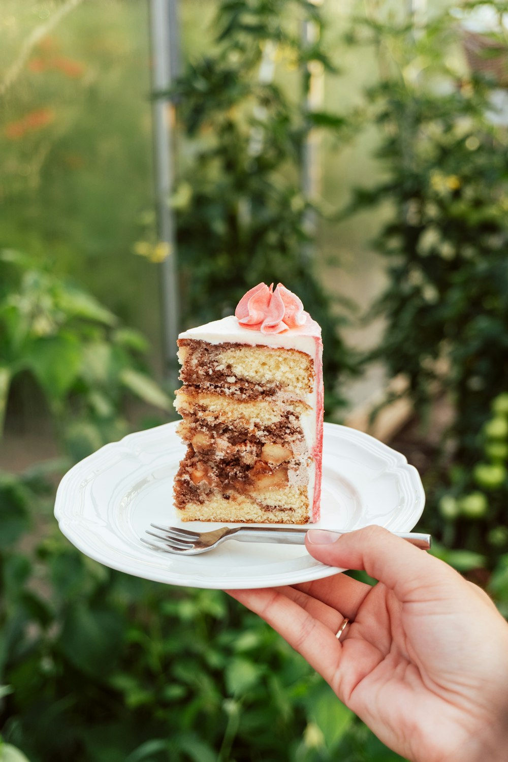 person holding white and brown cake on white ceramic plate