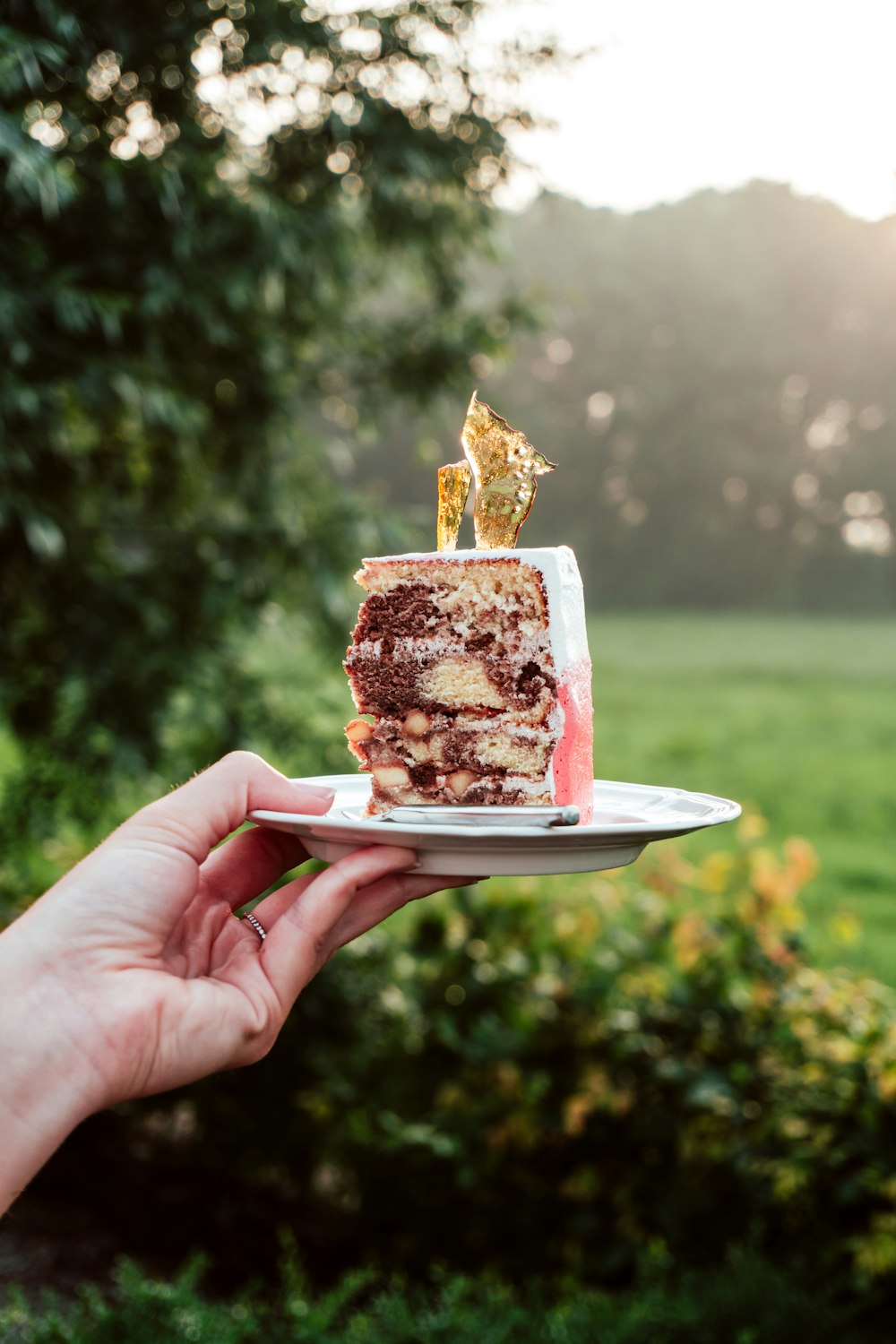 person holding sliced of cake