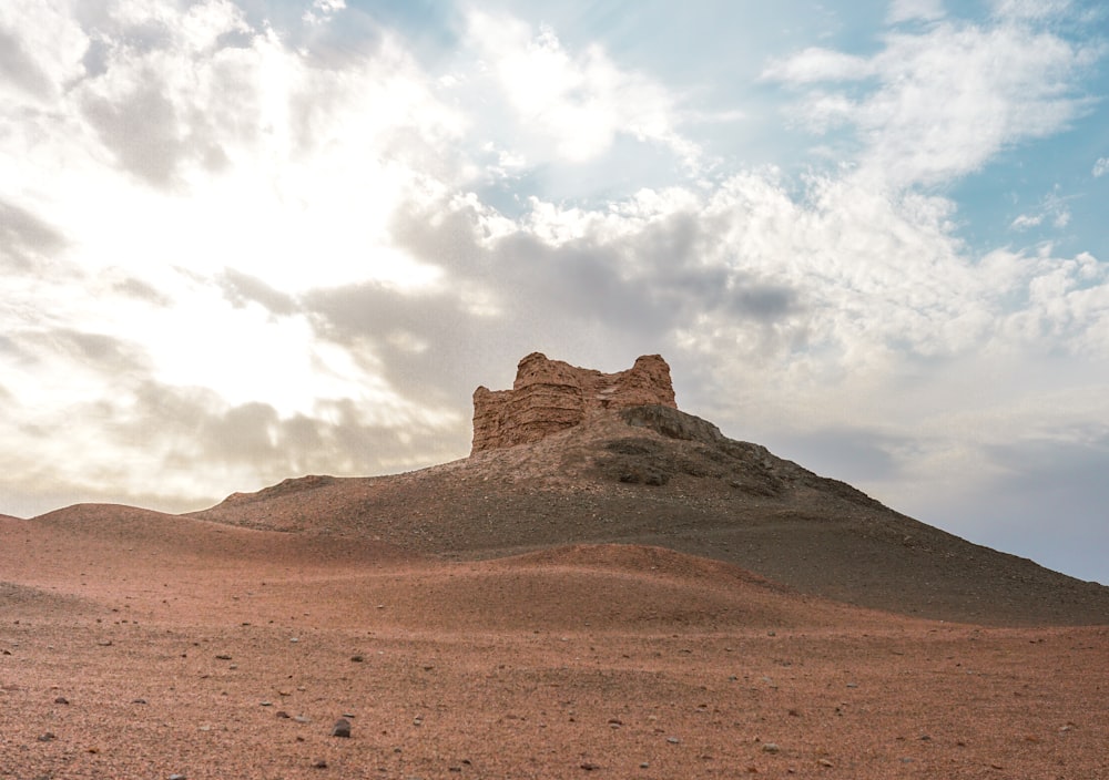 brown rock formation under white clouds during daytime