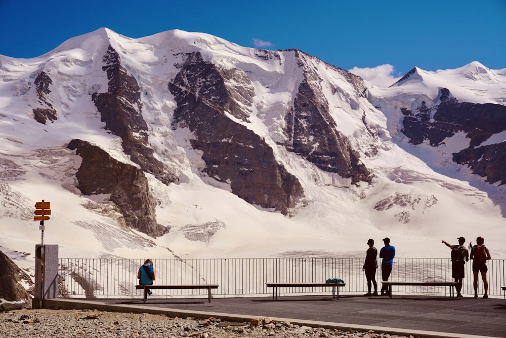 2 personnes marchant sur la route près d’une montagne enneigée pendant la journée