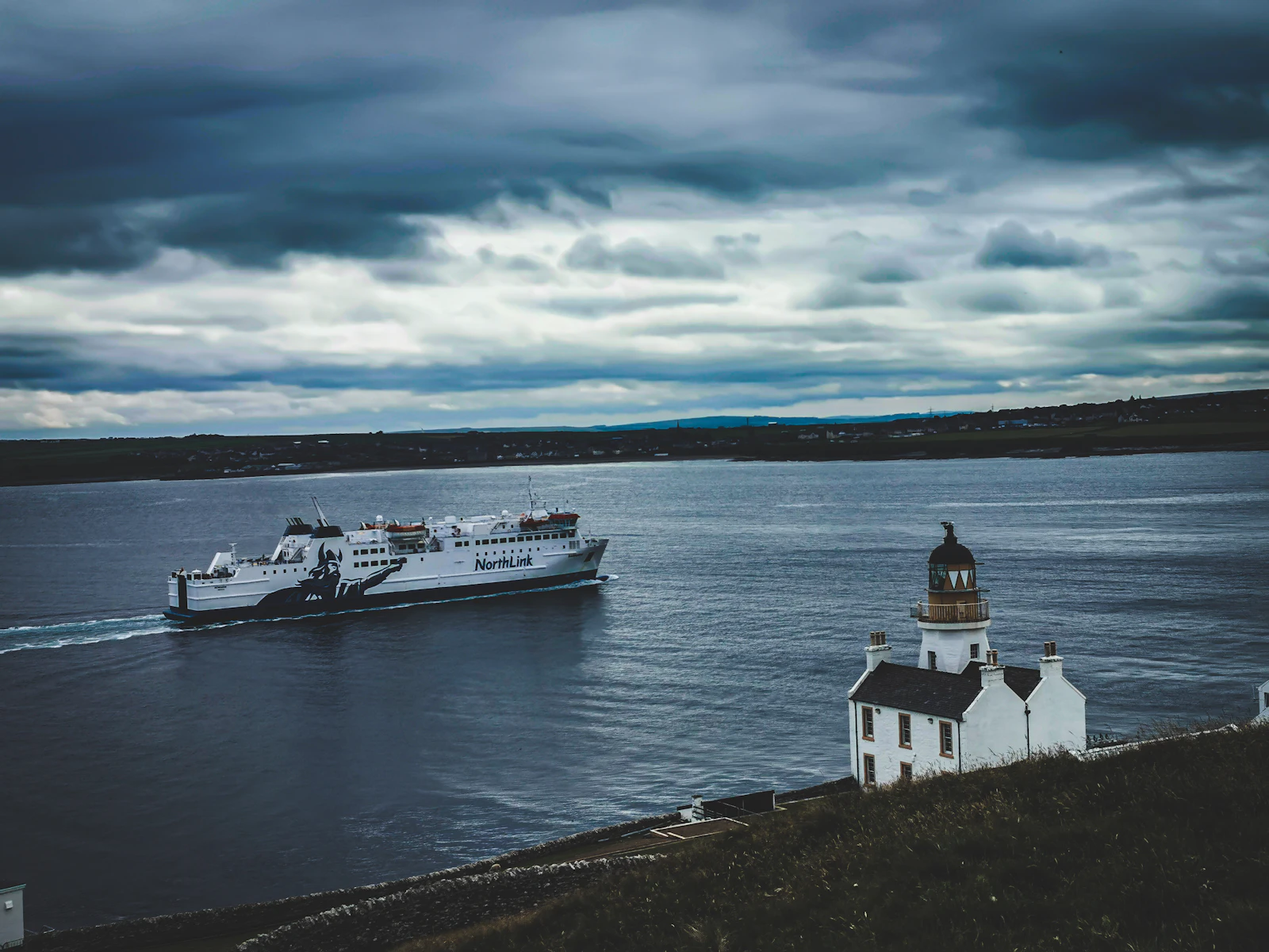 The ferry passing a lighthouse in Orkney’s waters — Orkney, United Kingdom