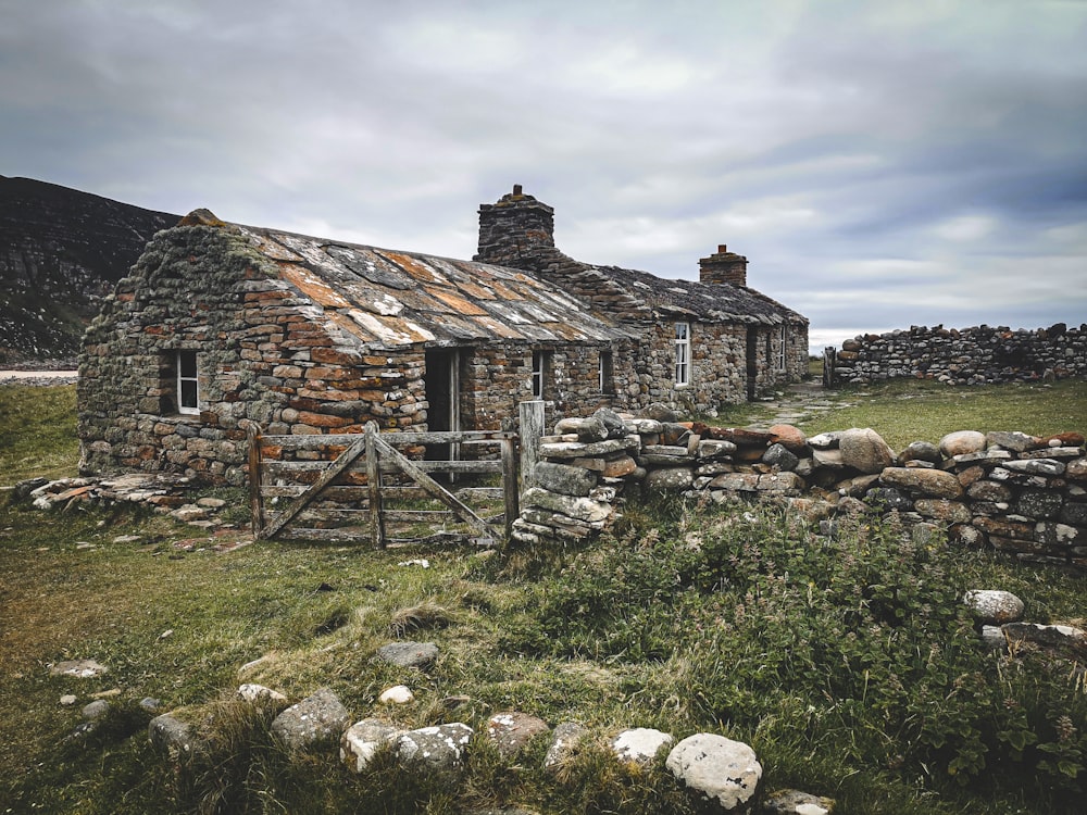 an old stone house with a rusty roof