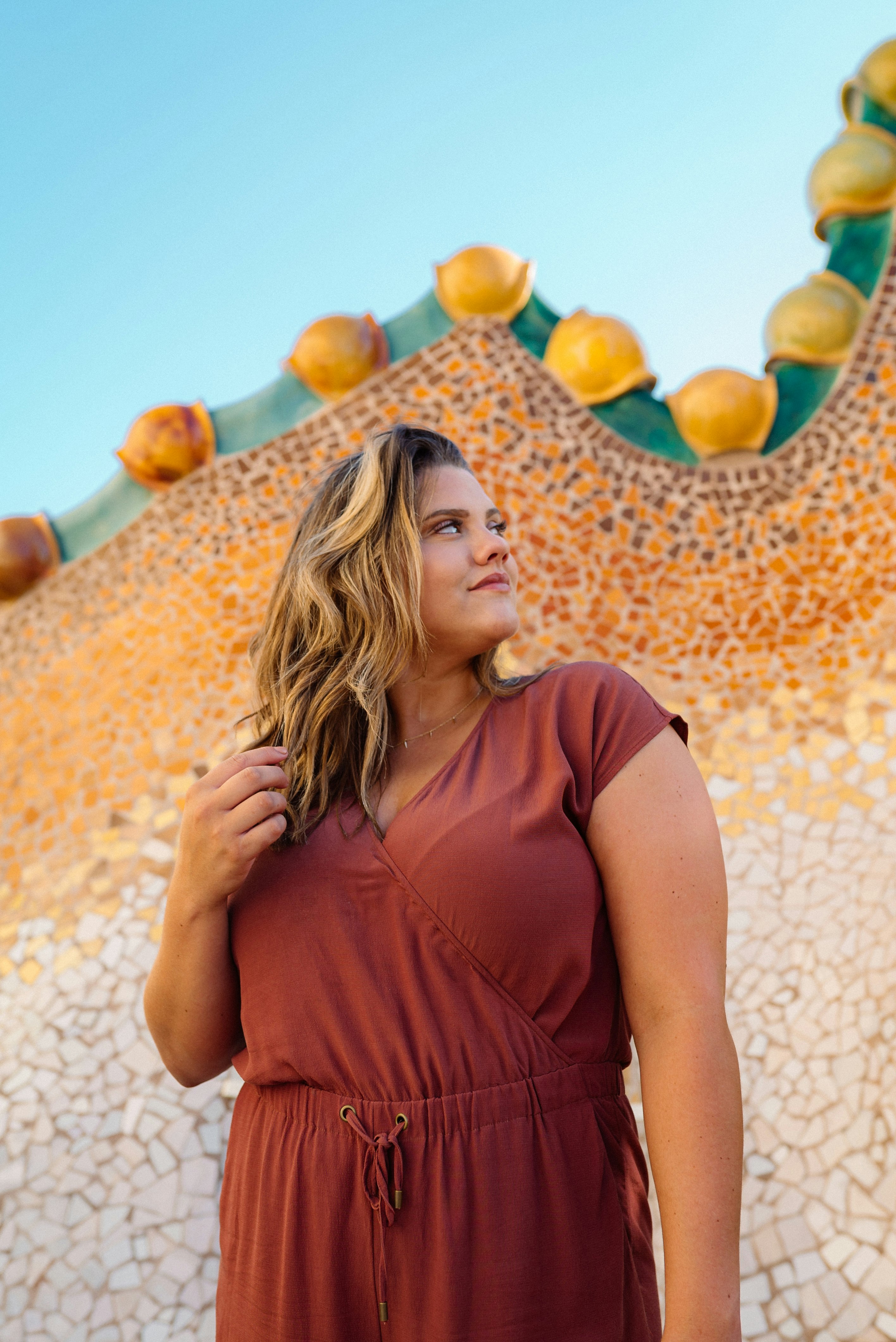 woman in brown sleeveless dress standing on white and yellow floral wall during daytime