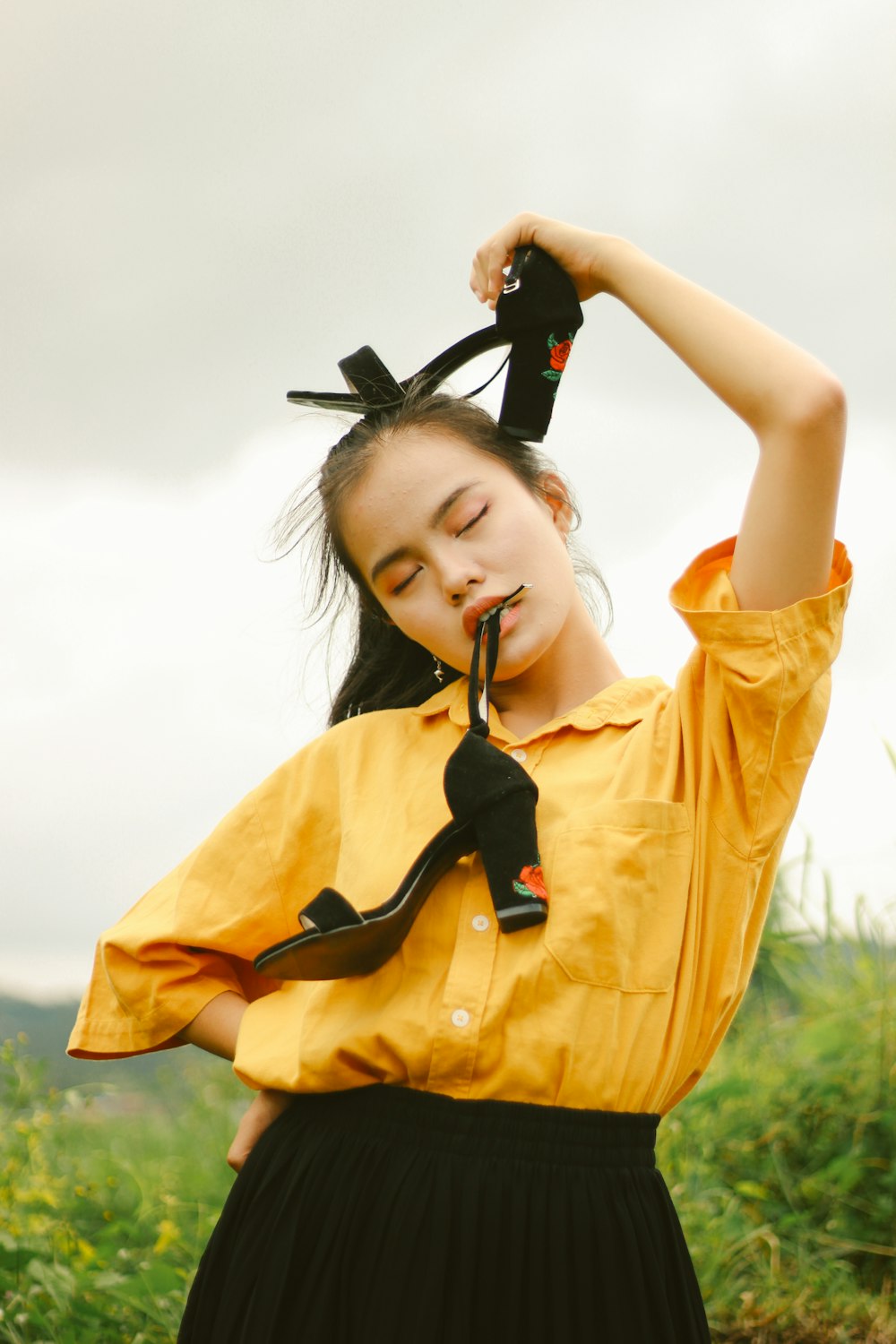 woman in yellow long sleeve shirt holding black and red headphones