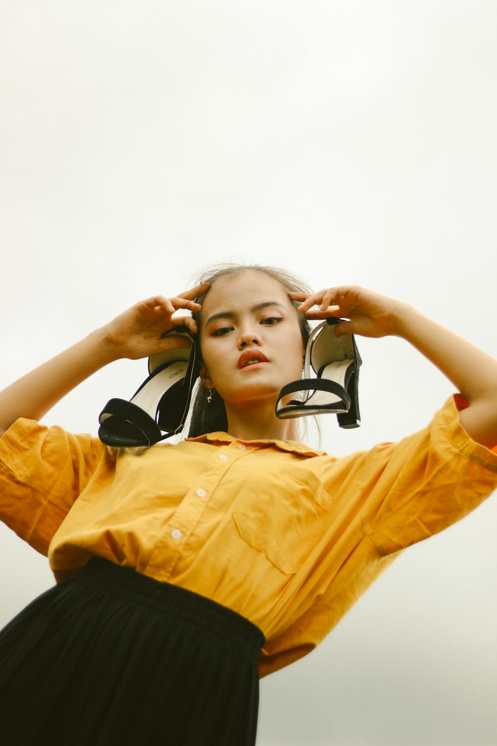 woman in yellow dress shirt with black headphones