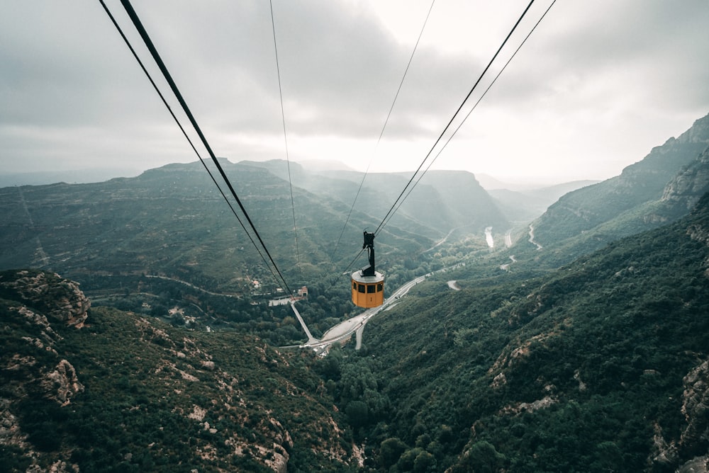 cable car over green mountains during daytime
