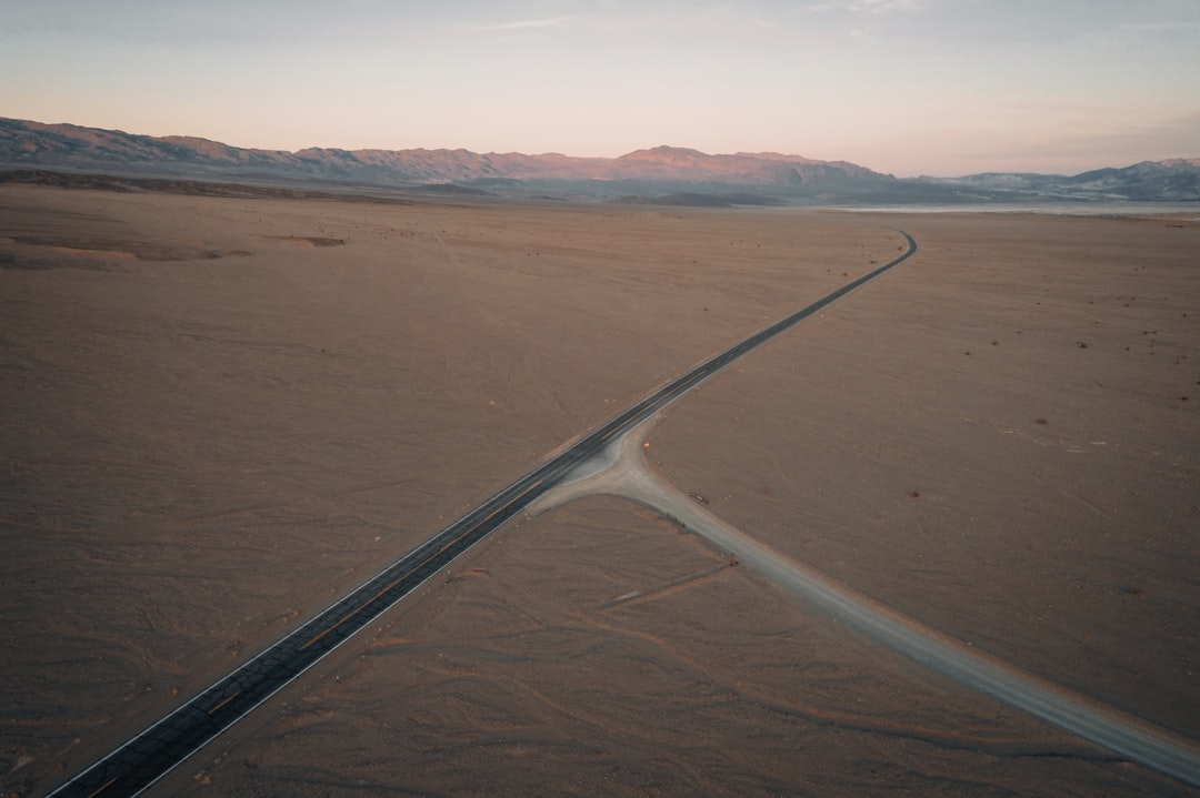 white metal railings on brown sand, Death Valley