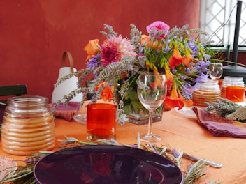 A dining area with a table set for a meal, featuring fresh flowers.