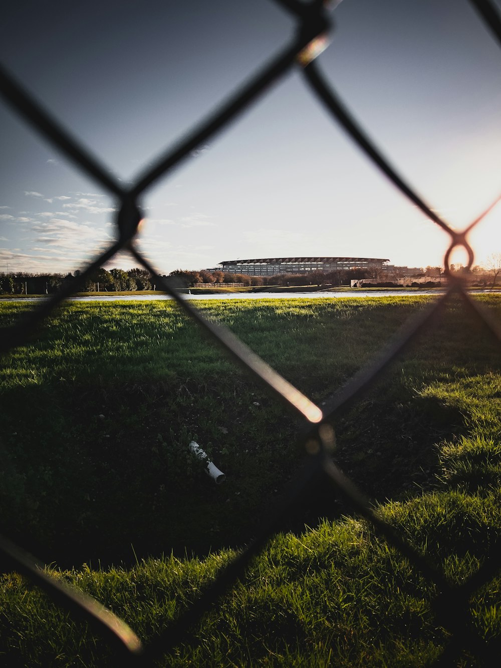 gray metal fence on green grass field during daytime