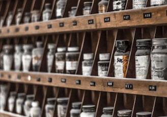 clear glass bottles on brown wooden shelf