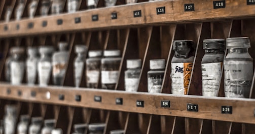 clear glass bottles on brown wooden shelf