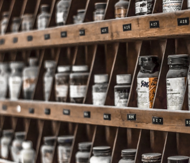 clear glass bottles on brown wooden shelf