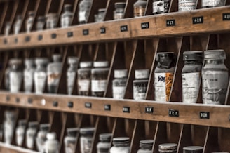 clear glass bottles on brown wooden shelf