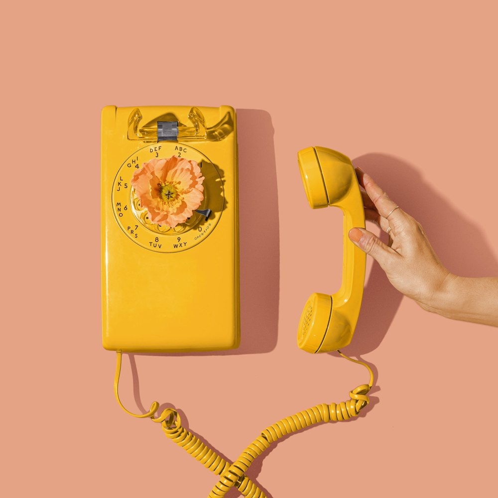 yellow and red telephone on yellow surface