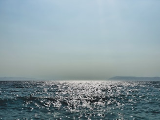 A serene ocean view with sparkling diamonds reflecting sunlight.