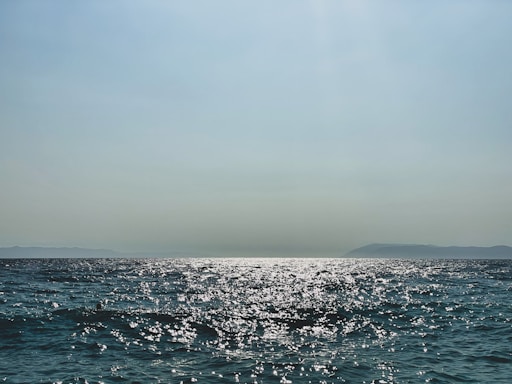 A serene ocean view with sparkling diamonds reflecting sunlight.