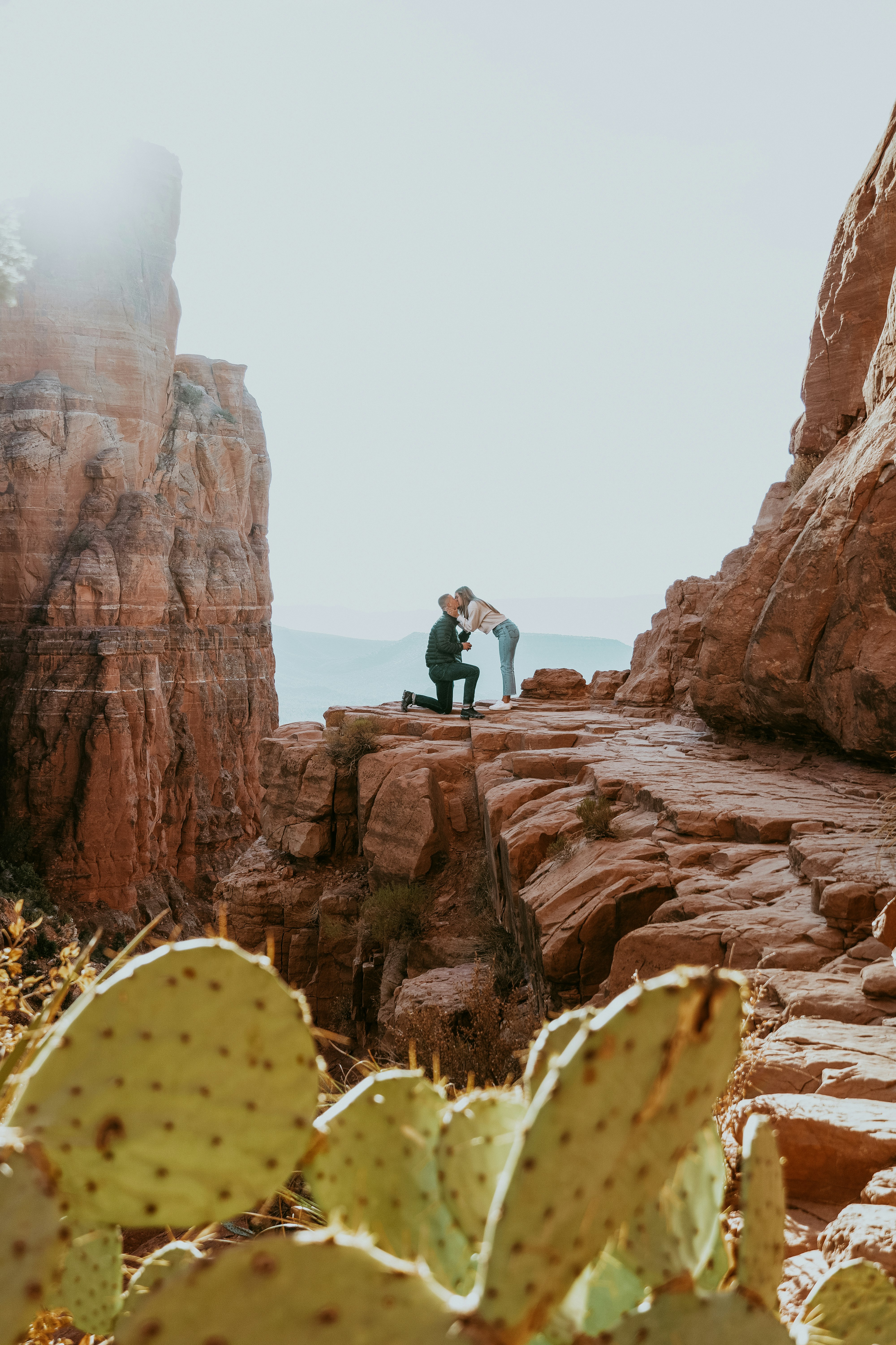 man in black jacket and black pants sitting on rock during daytime