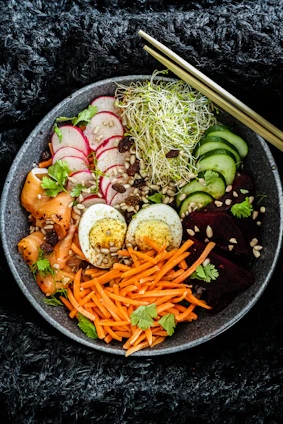 A beautifully arranged Asian fusion dish with vibrant colors and fresh ingredients on a rustic wooden table.