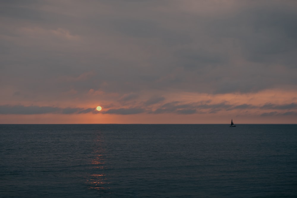 silhouette of boat on sea during sunset