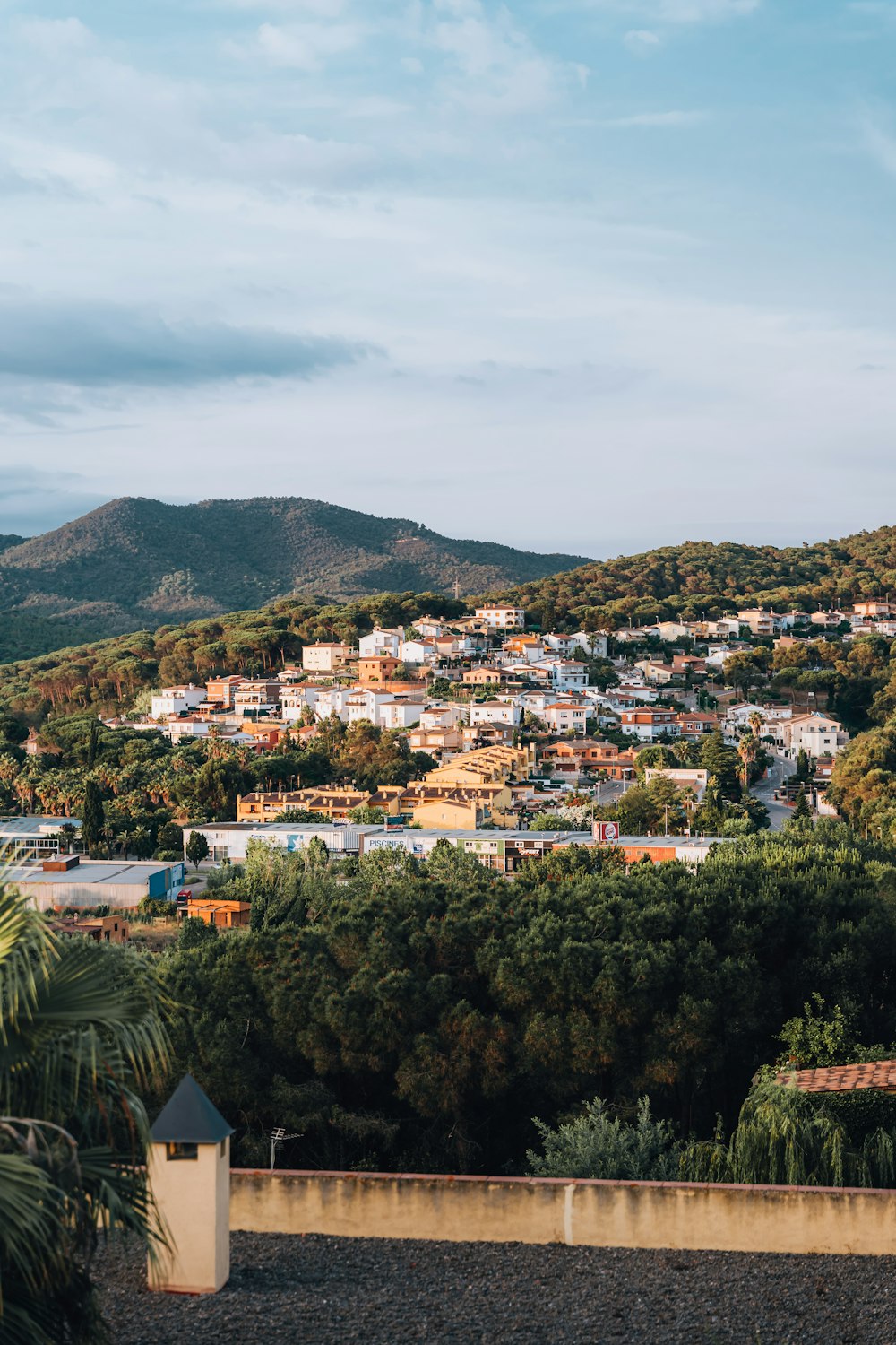 aerial view of city near green mountain during daytime