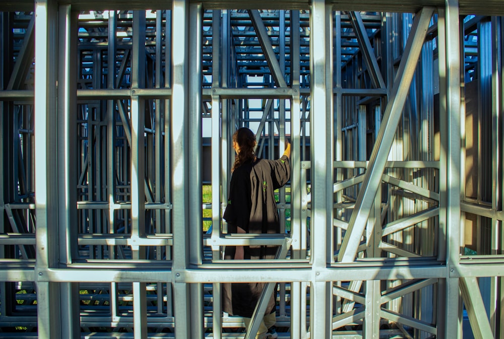 man in black jacket standing on gray metal frame